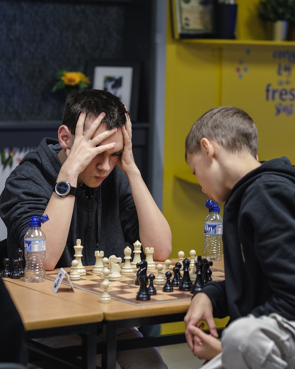 Two KoE Chess Club members play chess at a rapid tournament. 
