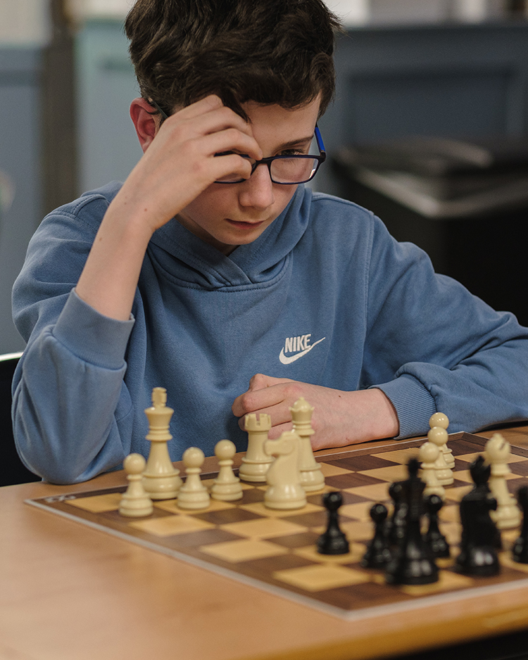 KoE chess club member concentrates at the chess board.