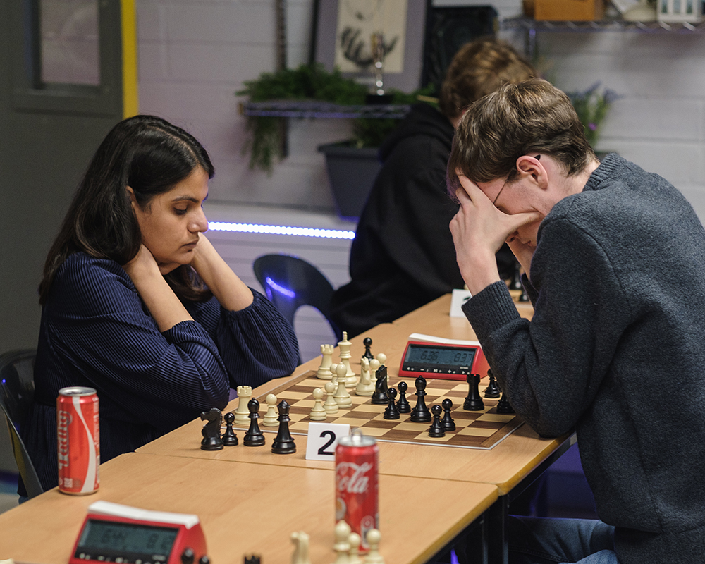 Two club chess players deep in thought during a chess game.