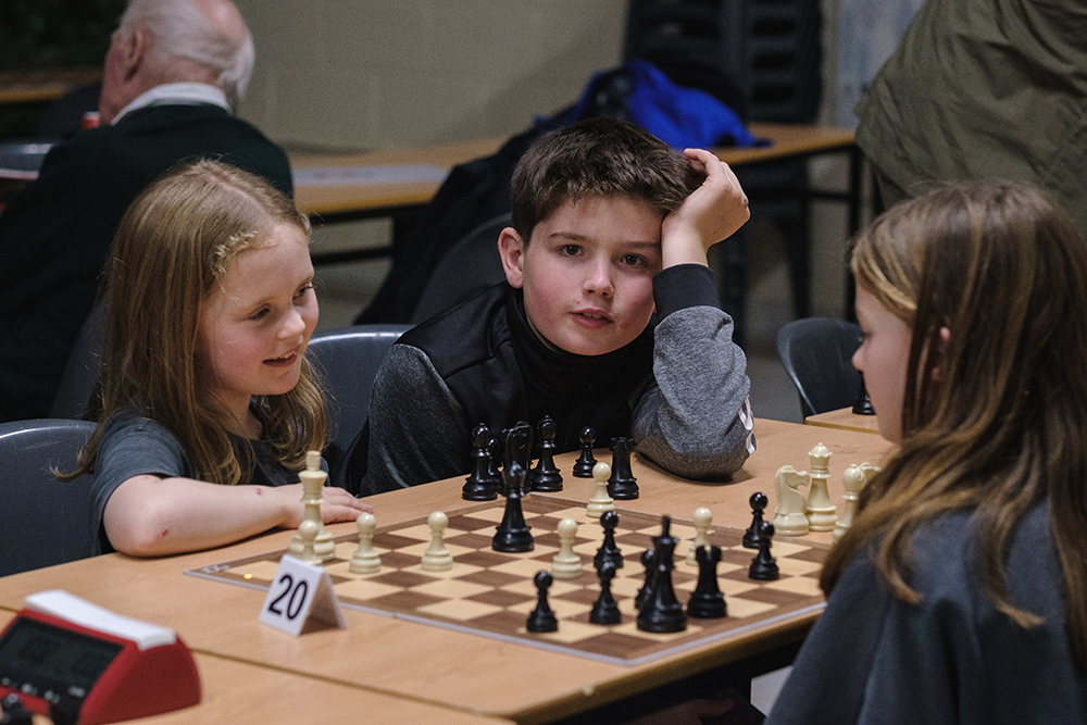 Two boys from KoE chess club play chess together.
