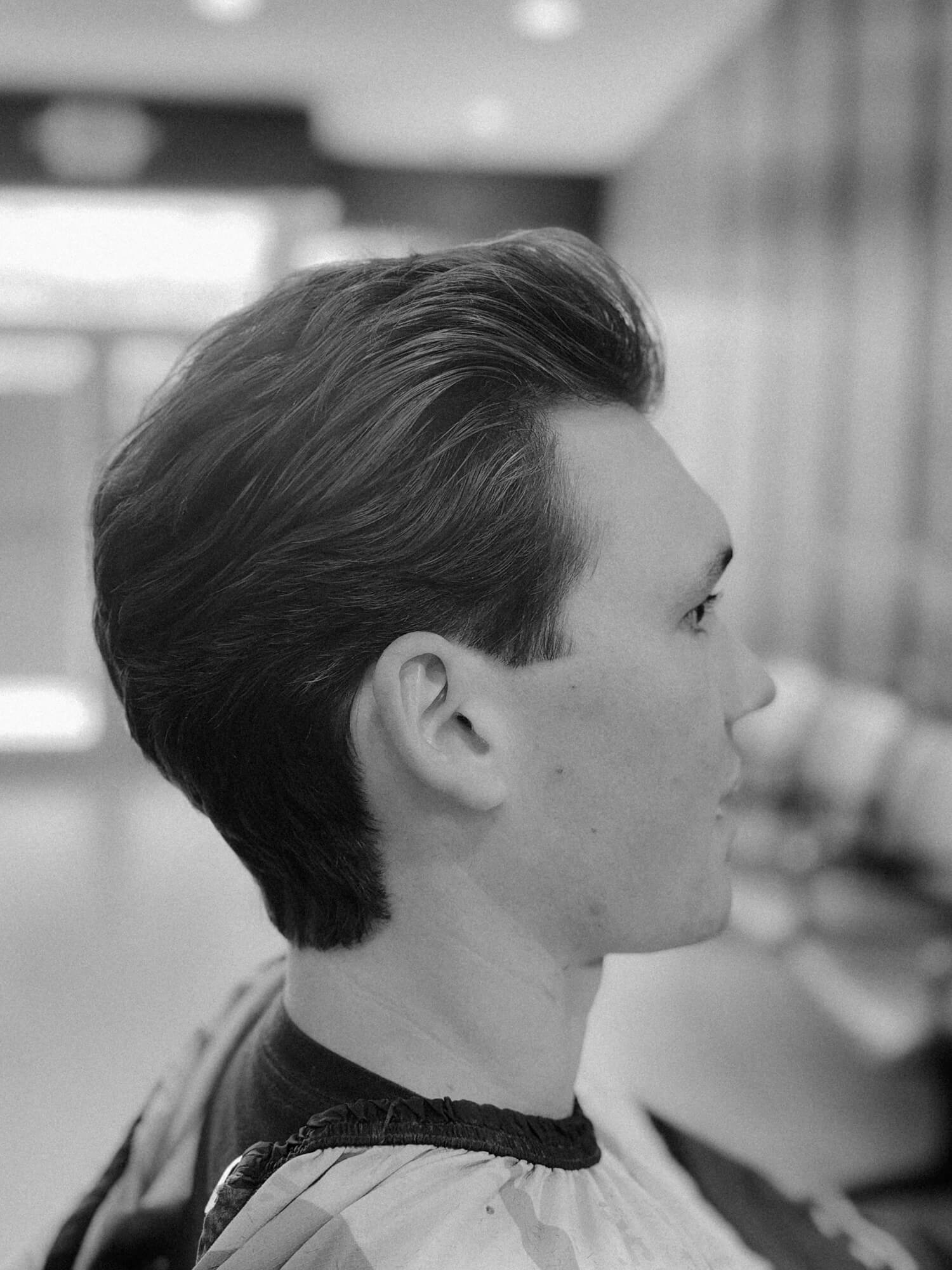 Side profile of a man with neatly styled dark hair cut at Center City Barbers.