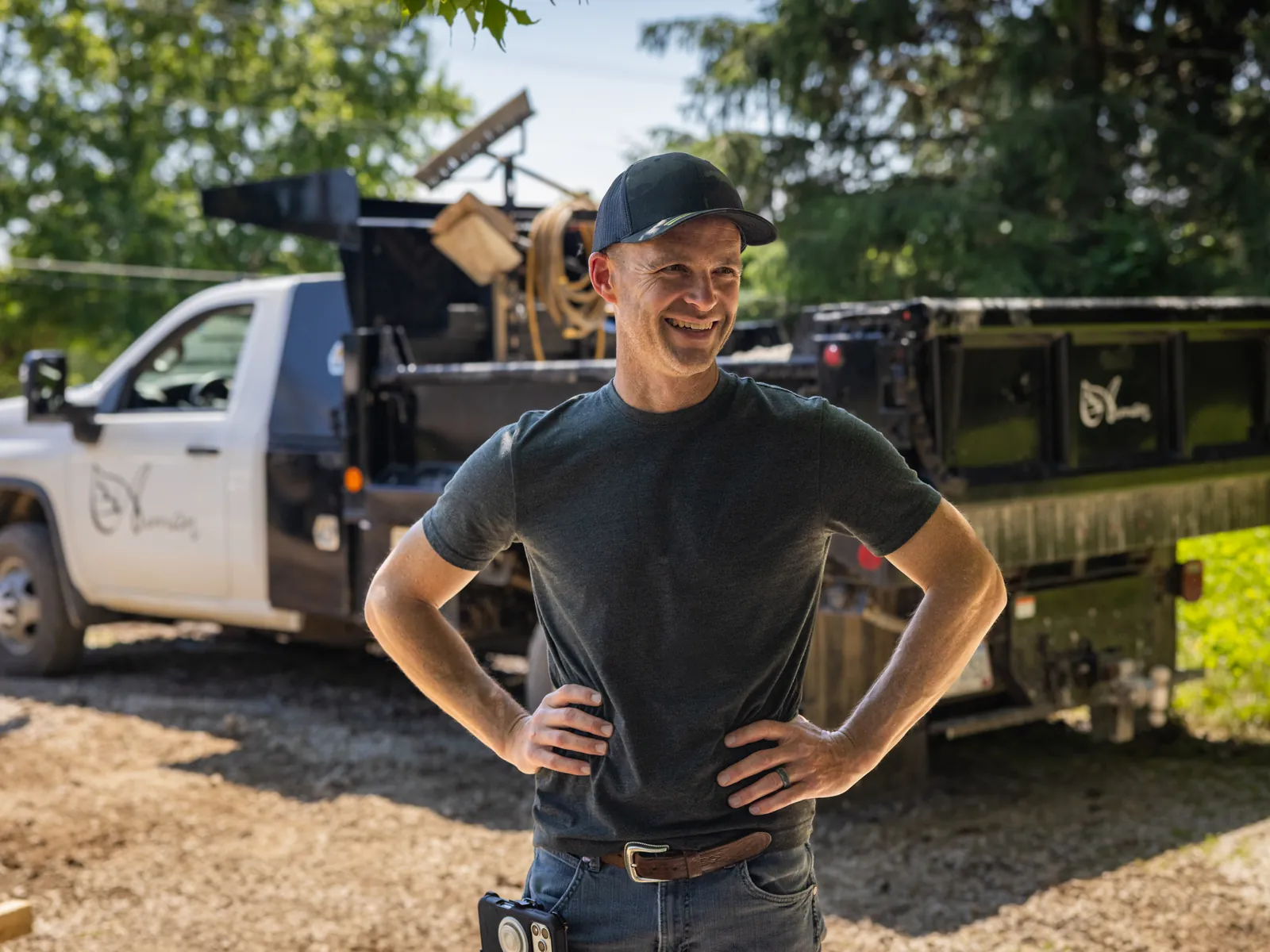 Caleb Auman smiling beside the Auman Outdoor trucks