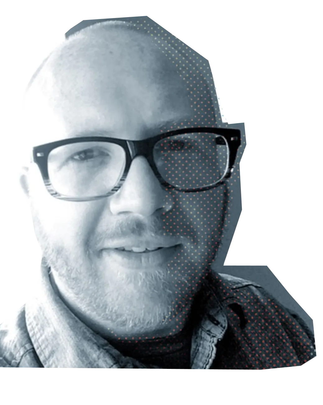 Close-up of a smiling bald man with glasses and a short beard wearing a denim shirt.