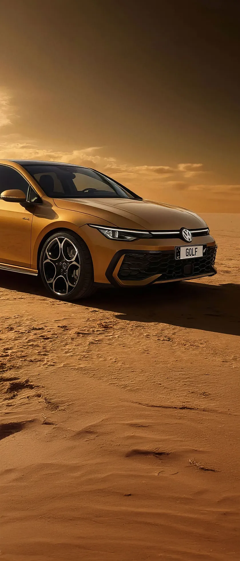 Golden Volkswagen Golf parked on sandy terrain under a dramatic sunset sky.