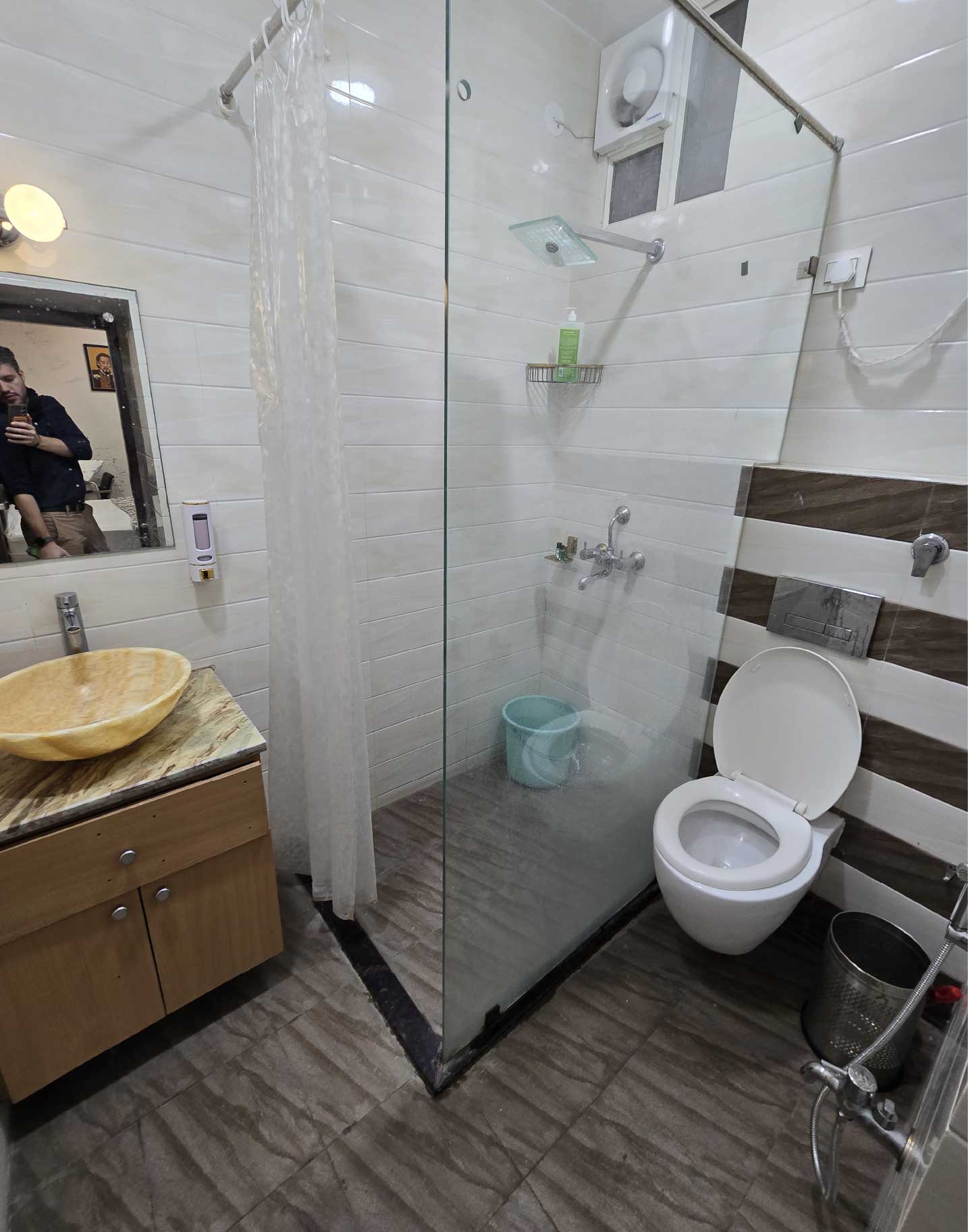 A bathroom with a glass-enclosed shower, a toilet, and a modern sink with a stylish countertop.