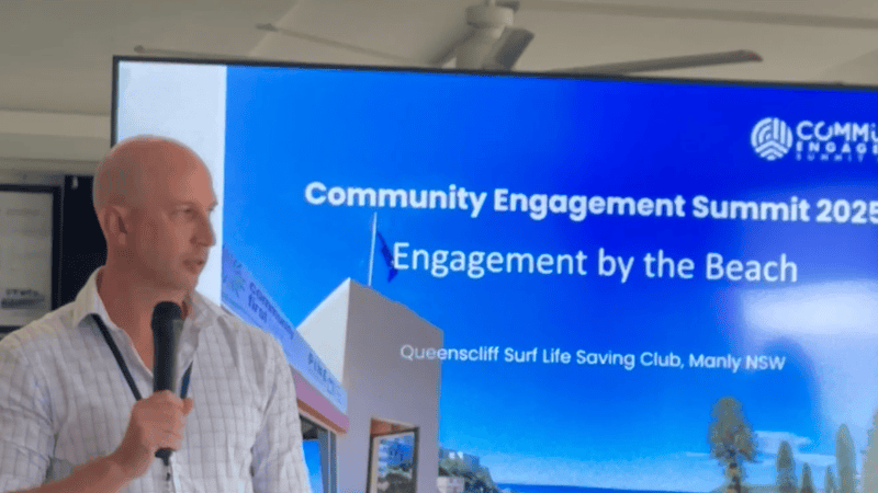 Man in light business shirt presenting in front of screen