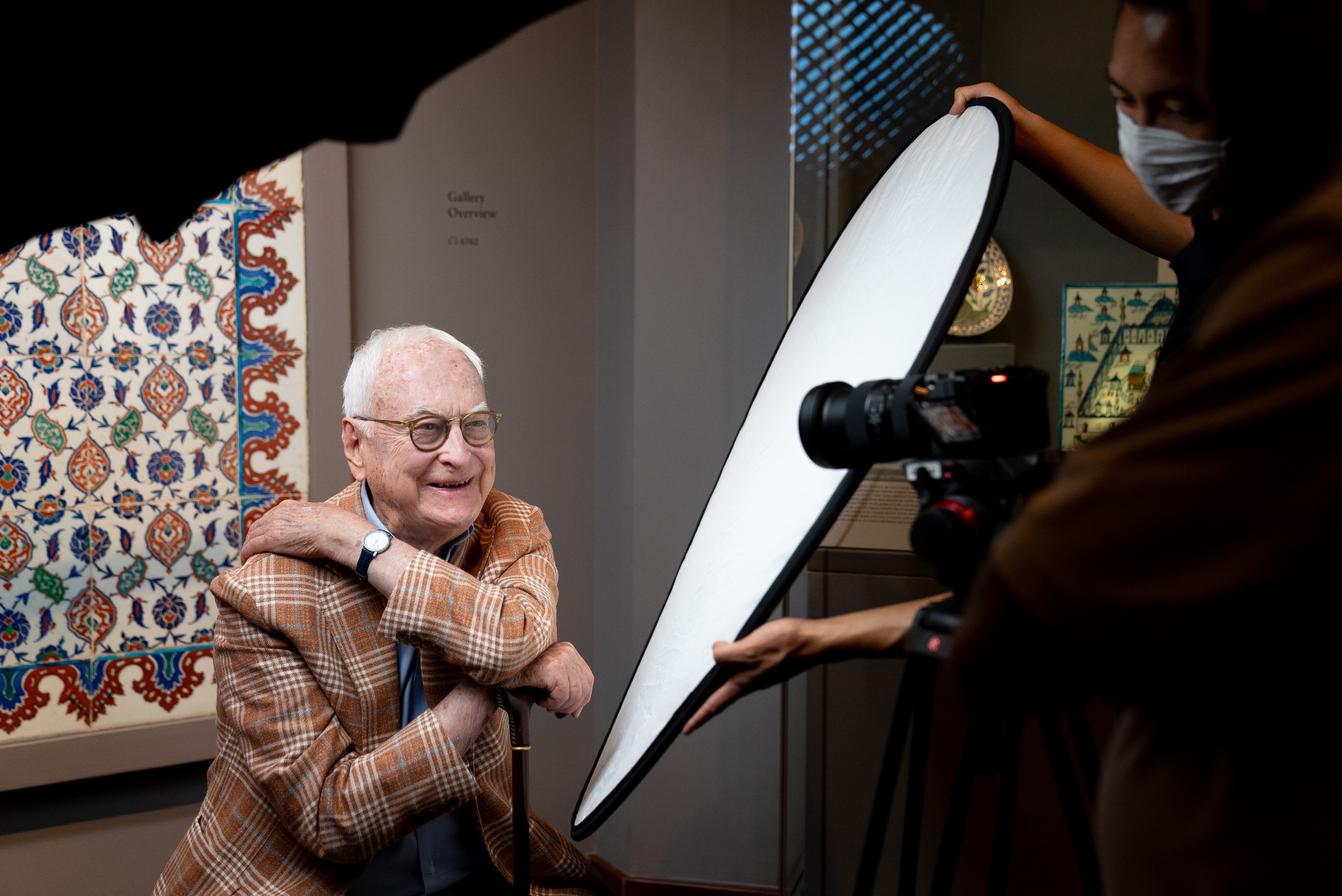 A young blonde girl in a red transparent scarf against a clear sky.