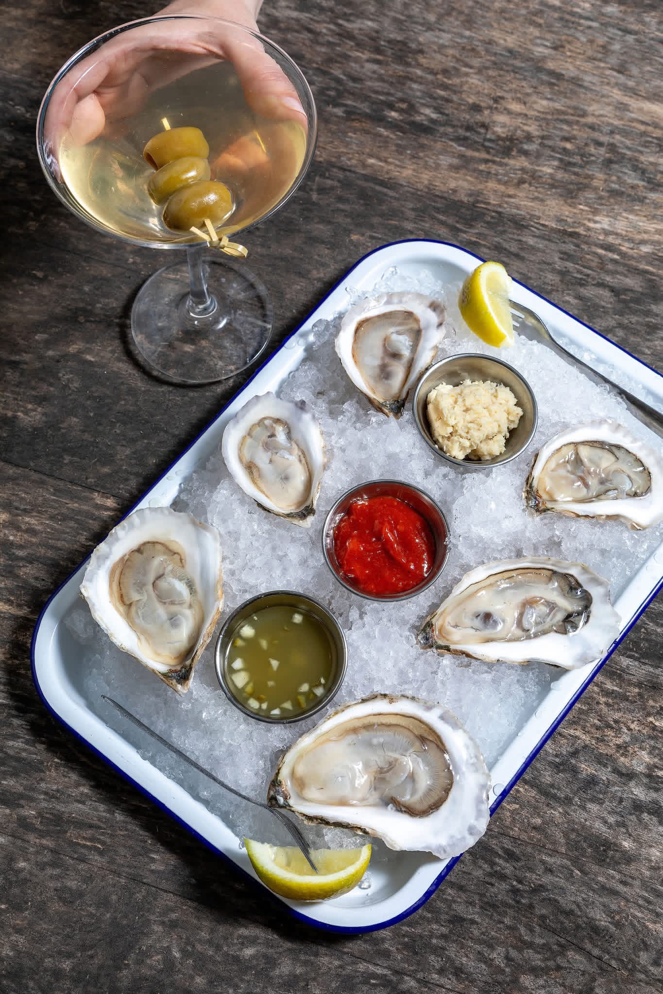 Mystic Mermaid oysters on the half shell, served on ice with lemon and dipping sauces