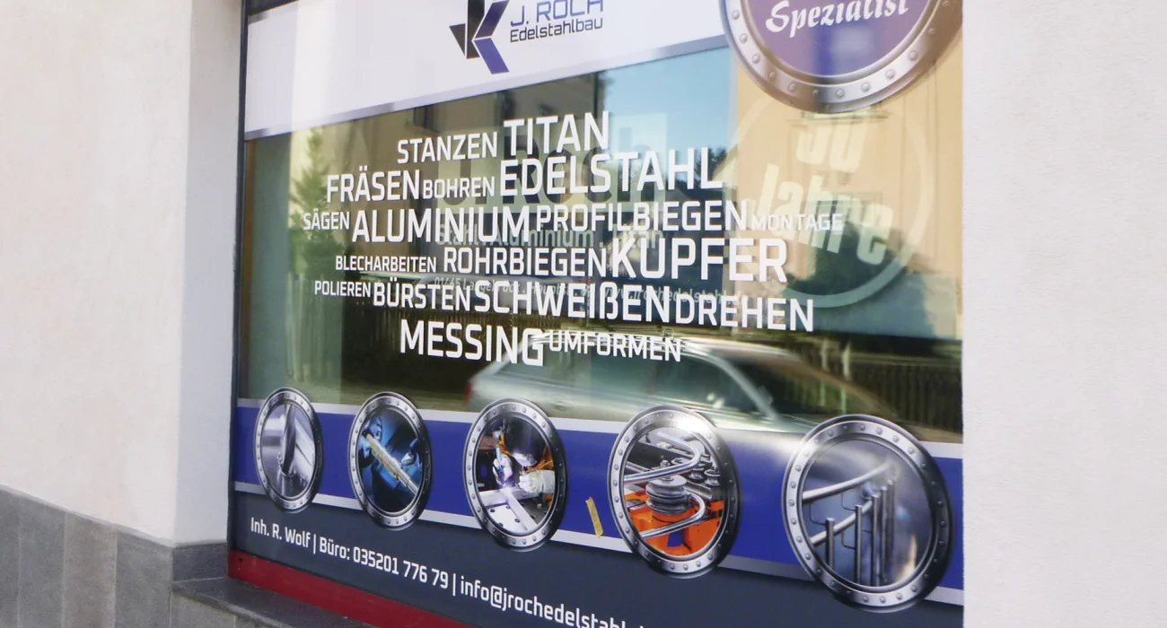 Professionelle Schaufensterbeschriftung mit Firmenlogo und Leistungsübersicht