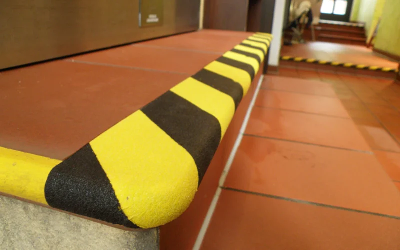 Gelb schwarze Sicherheitsfolie auf einer Treppe als rutschfeste Warnmarkierung