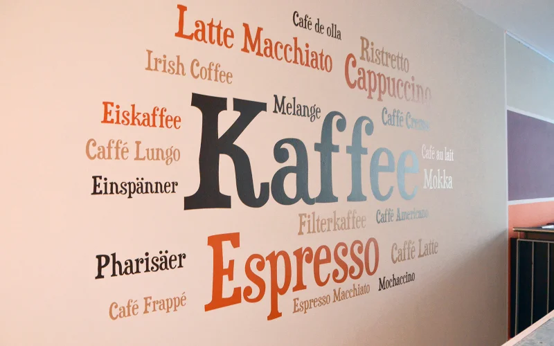 Folien Wandbeschriftung mit Kaffeesorten und Typografie in einem Café.