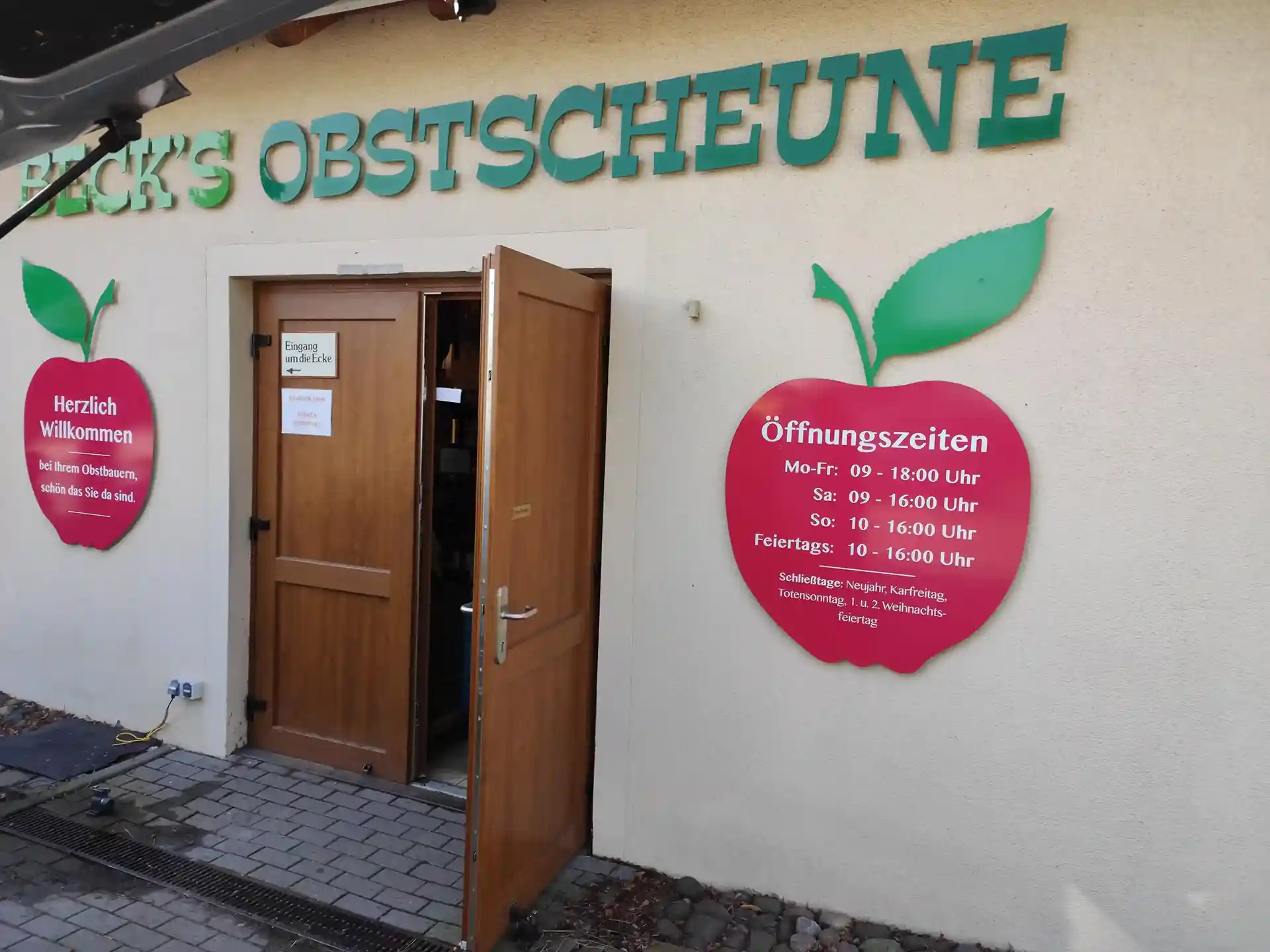 Außenbeschilderung und Fassadenwerbung an einem Geschäft – individuelle Werbetechnik mit Logos und Öffnungszeiten.