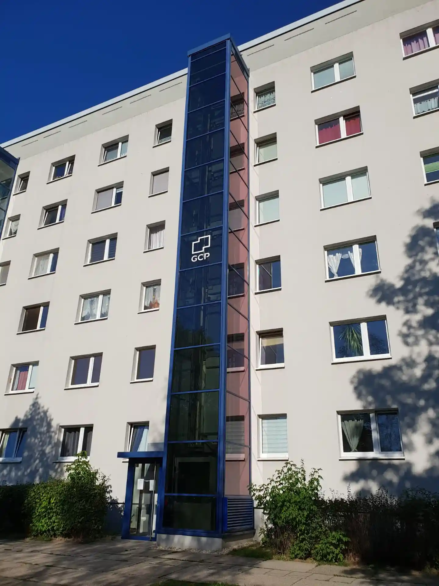 Mehrstöckiges Wohngebäude mit großen Fenstern mit Sonnenschutzfolie