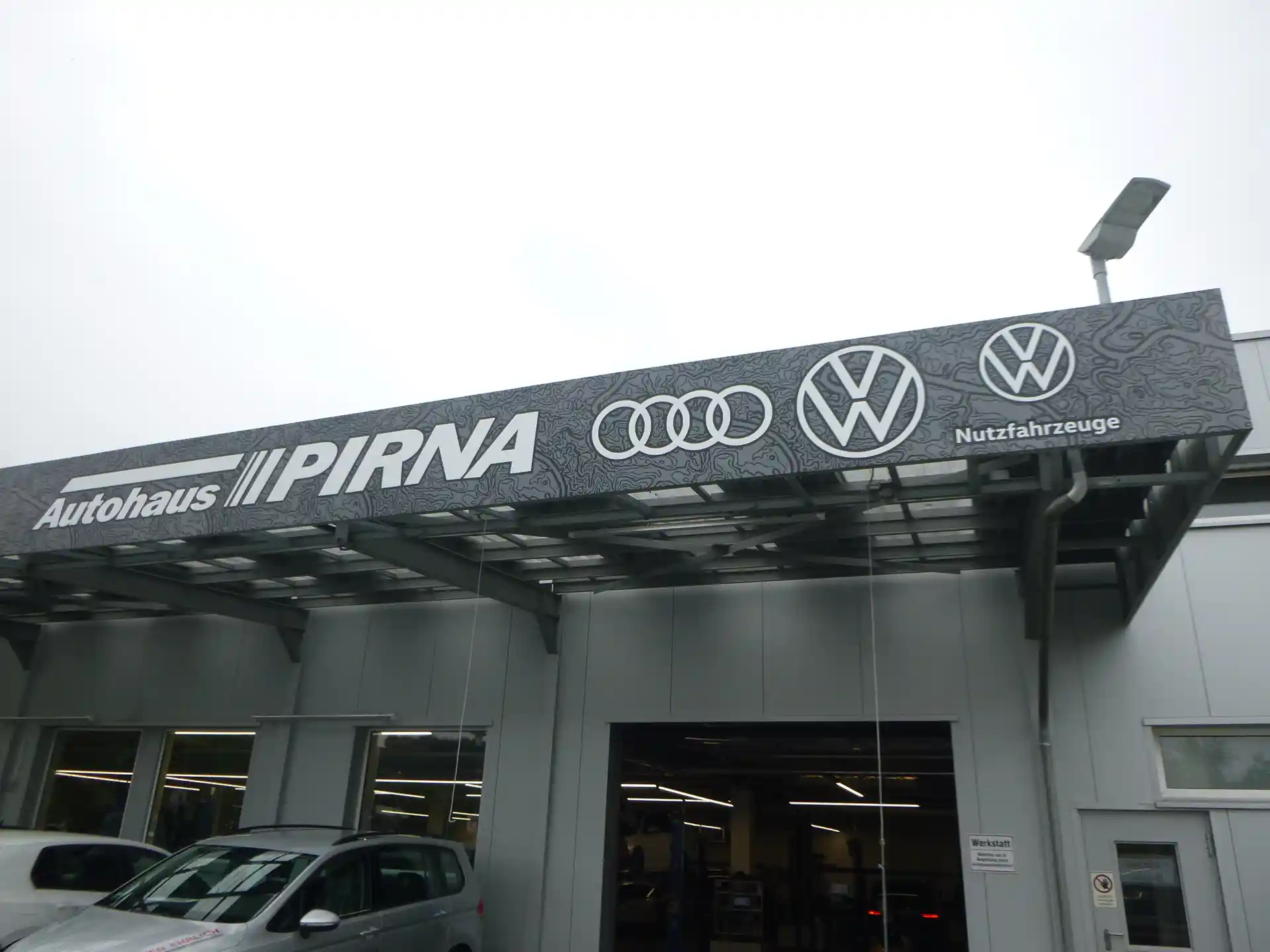 Großflächige Fassadenwerbung mit Firmenlogo an einem Autohausgebäude