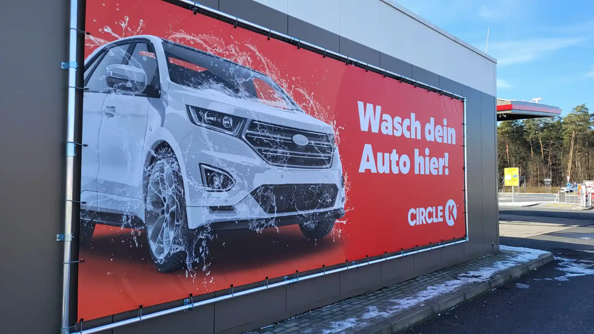 Großformatiger Werbebanner für Autowaschanlage als Außenwerbung an Gebäudefassade