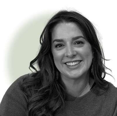 Smiling woman with long dark hair wearing a sweater against a green circle background.