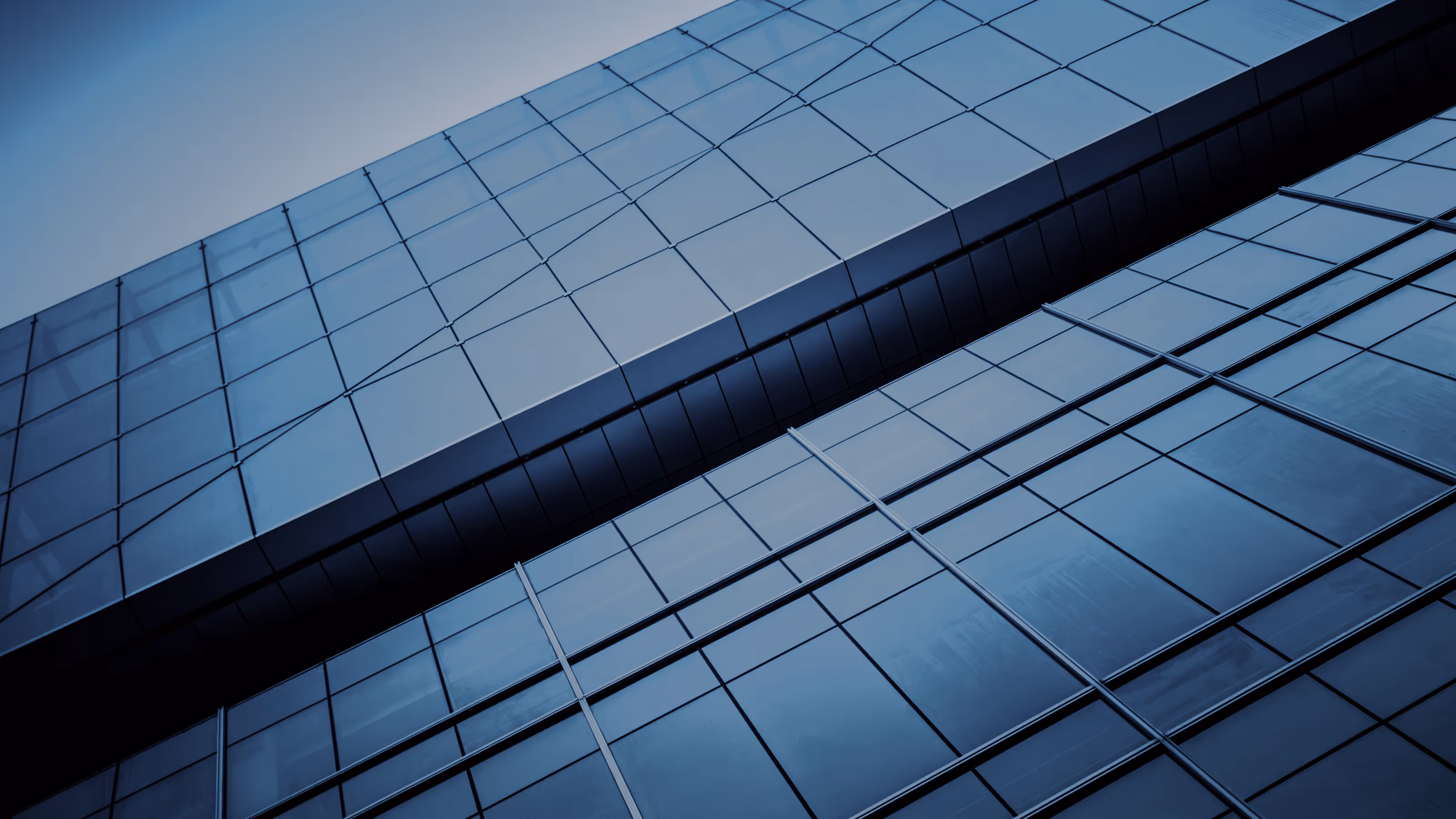 Close-up of a modern glass building facade with reflective windows and metal framing.