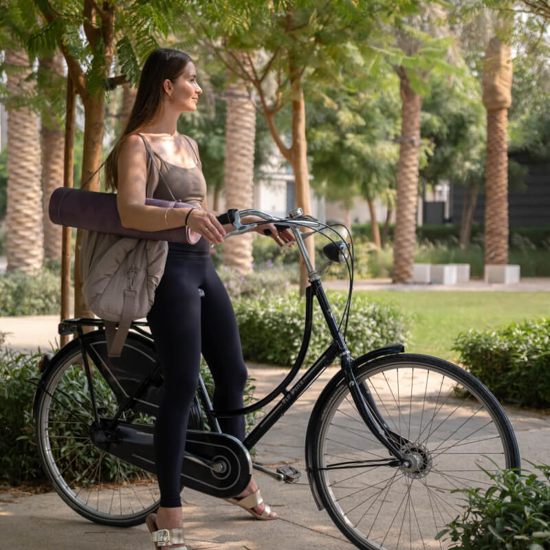 Lady on bicycle with yoga matt
