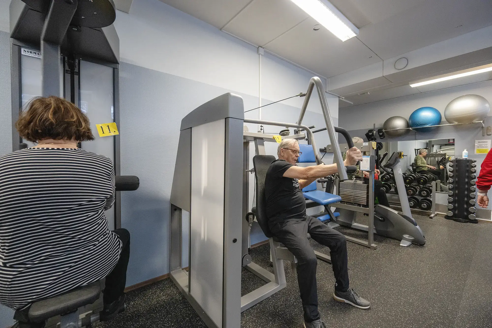 Ryhmä ihmisiä kuntoilemassa kuntosalilla yhdessä.