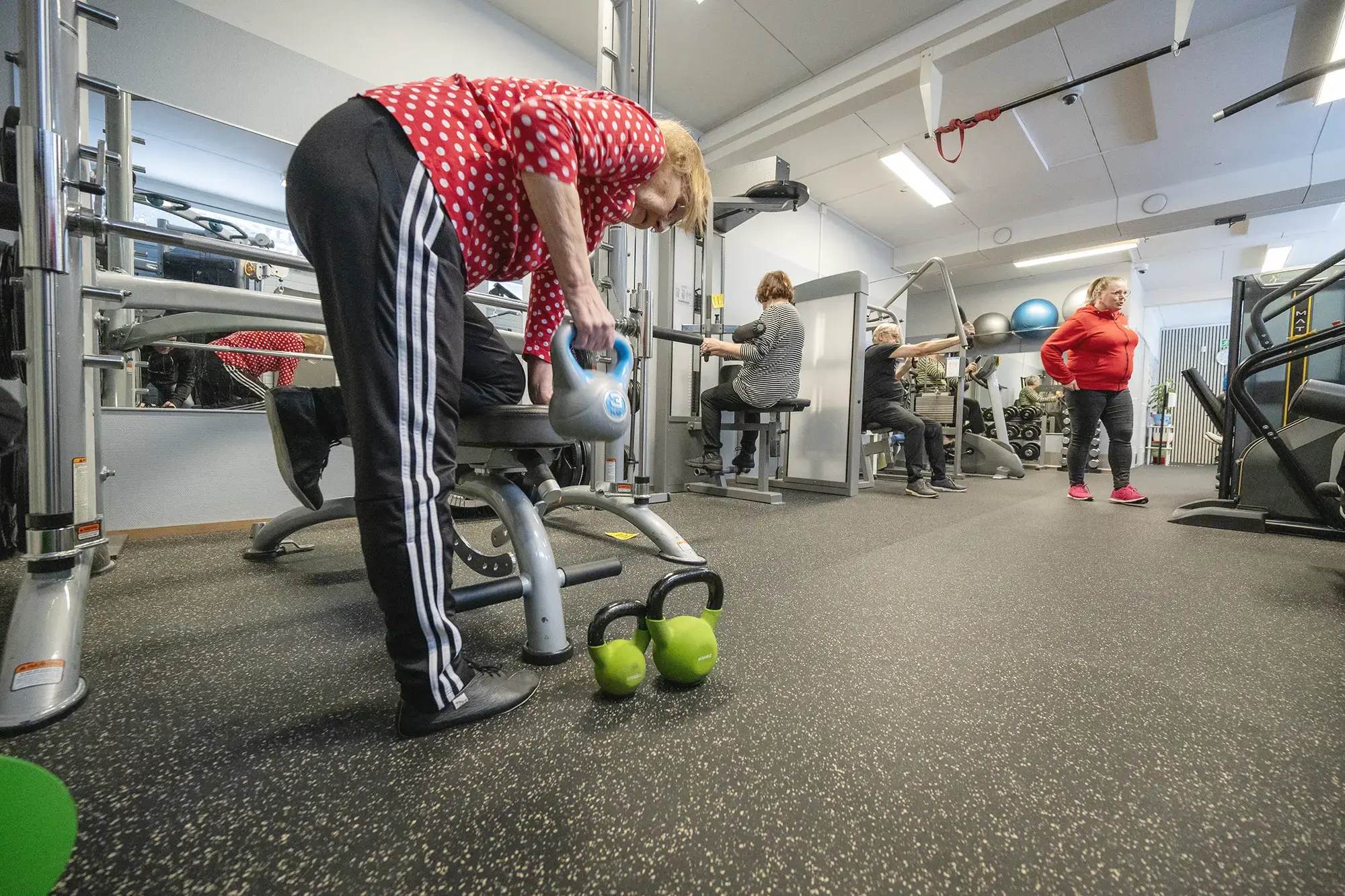 Ryhmä ihmisiä kuntoilemassa kuntosalilla yhdessä.