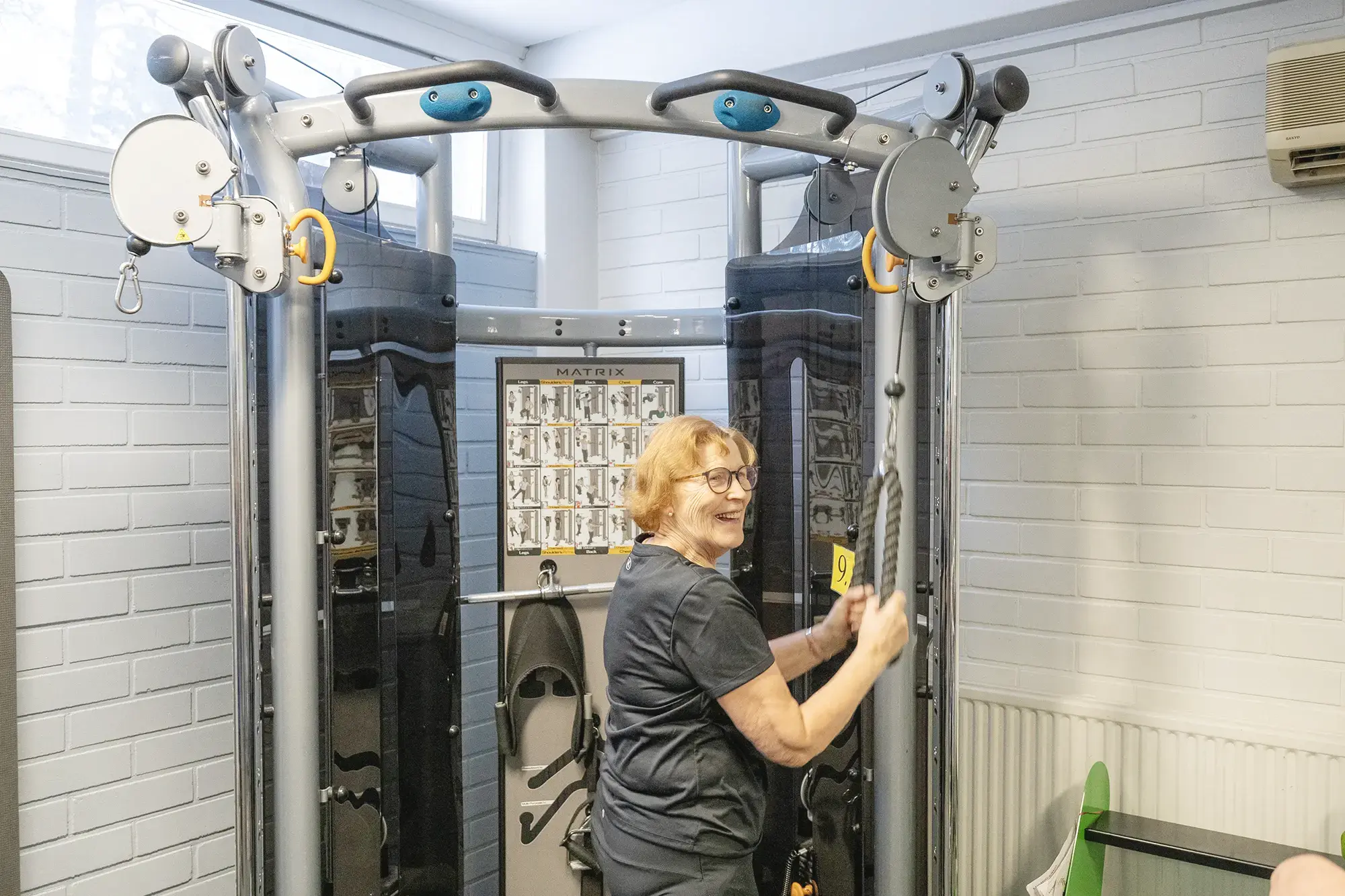 Ryhmä ihmisiä kuntoilemassa kuntosalilla yhdessä.