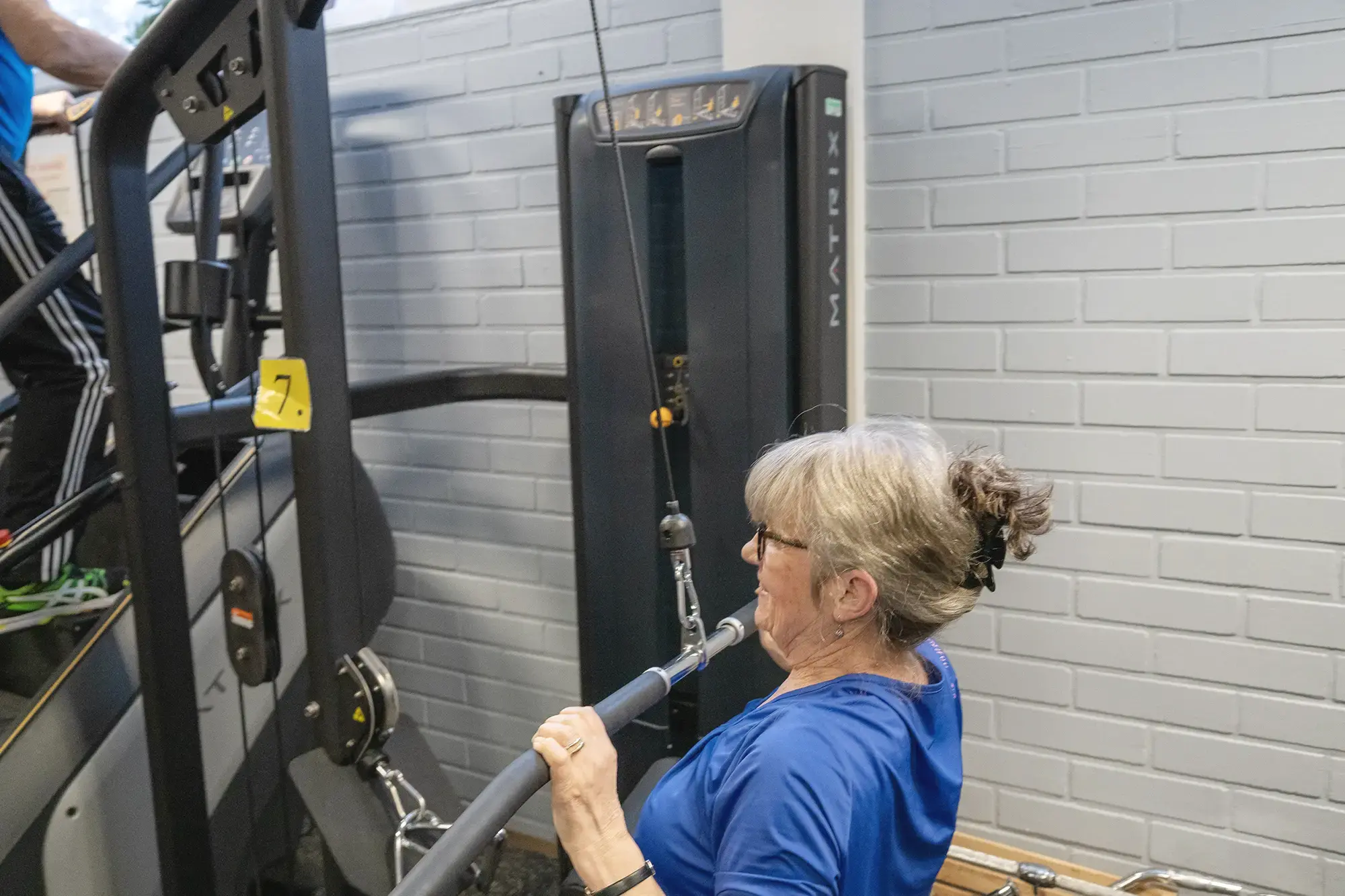 Ryhmä ihmisiä kuntoilemassa kuntosalilla yhdessä.