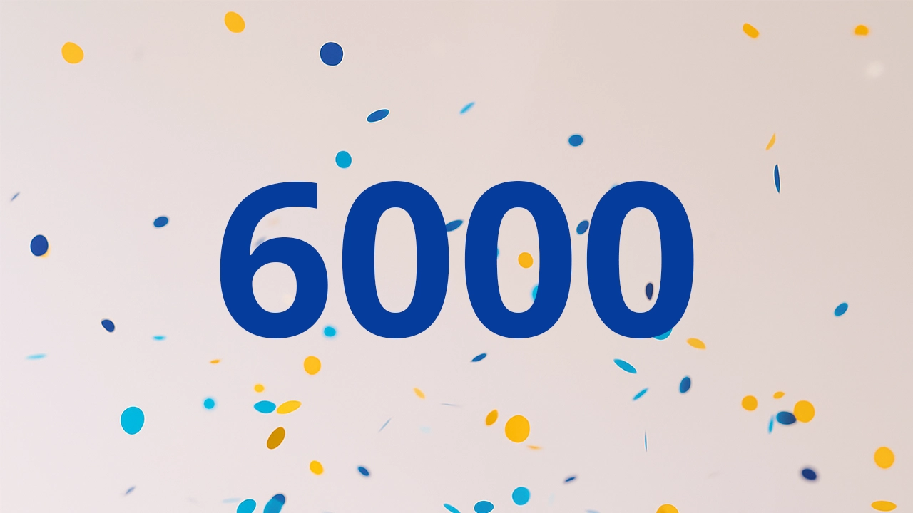 6000 in blue numbers on a white background of blue and yellow dots