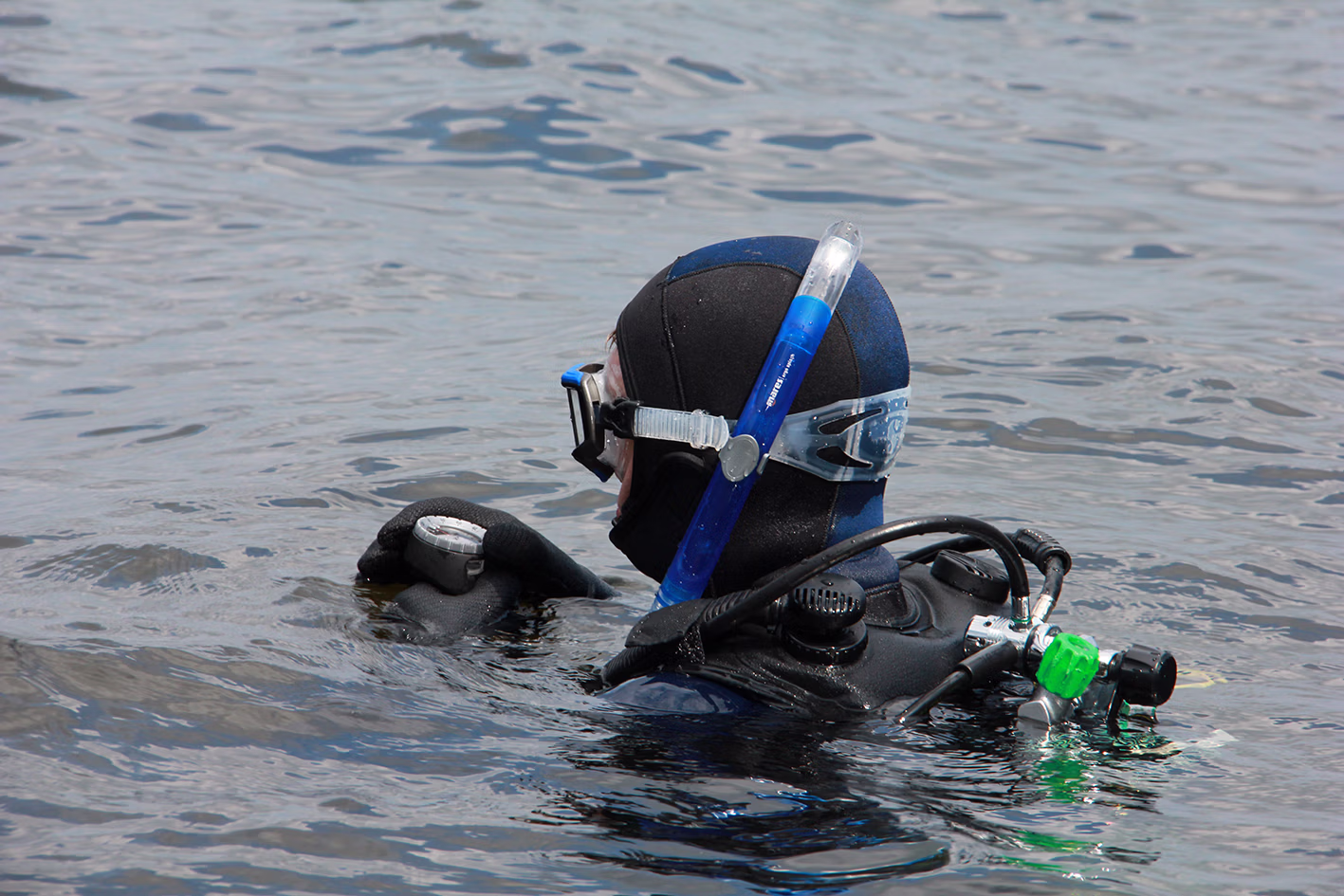 een duiker ligt in het buitenwater en kijkt op zijn kompas