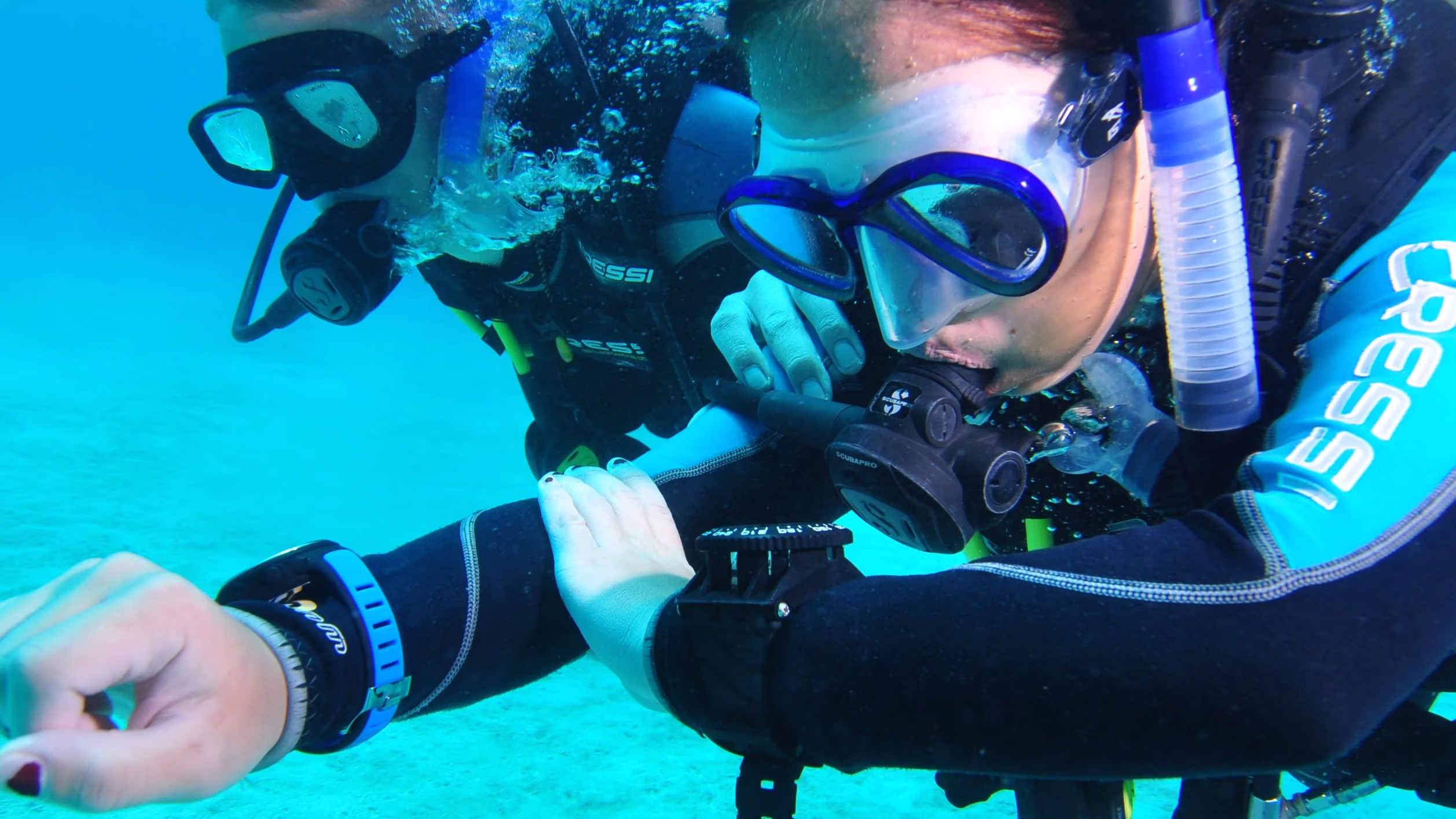 Man in duikpak navigeert terwijl hij onderwater duikt
