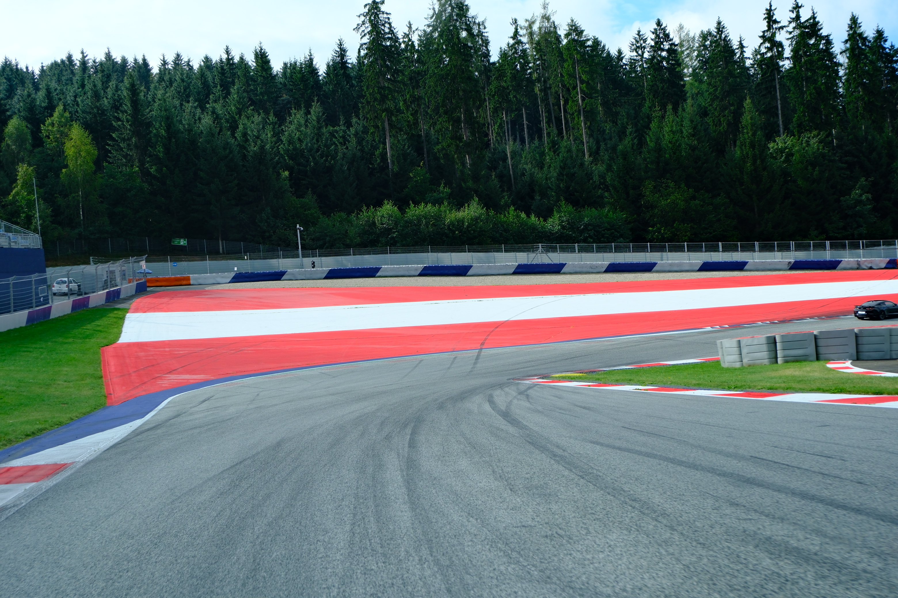 Blick auf einem Sportwagen heraus auf die letzte Kurve vor der Zielgeraden auf dem Red Bull Ring.
