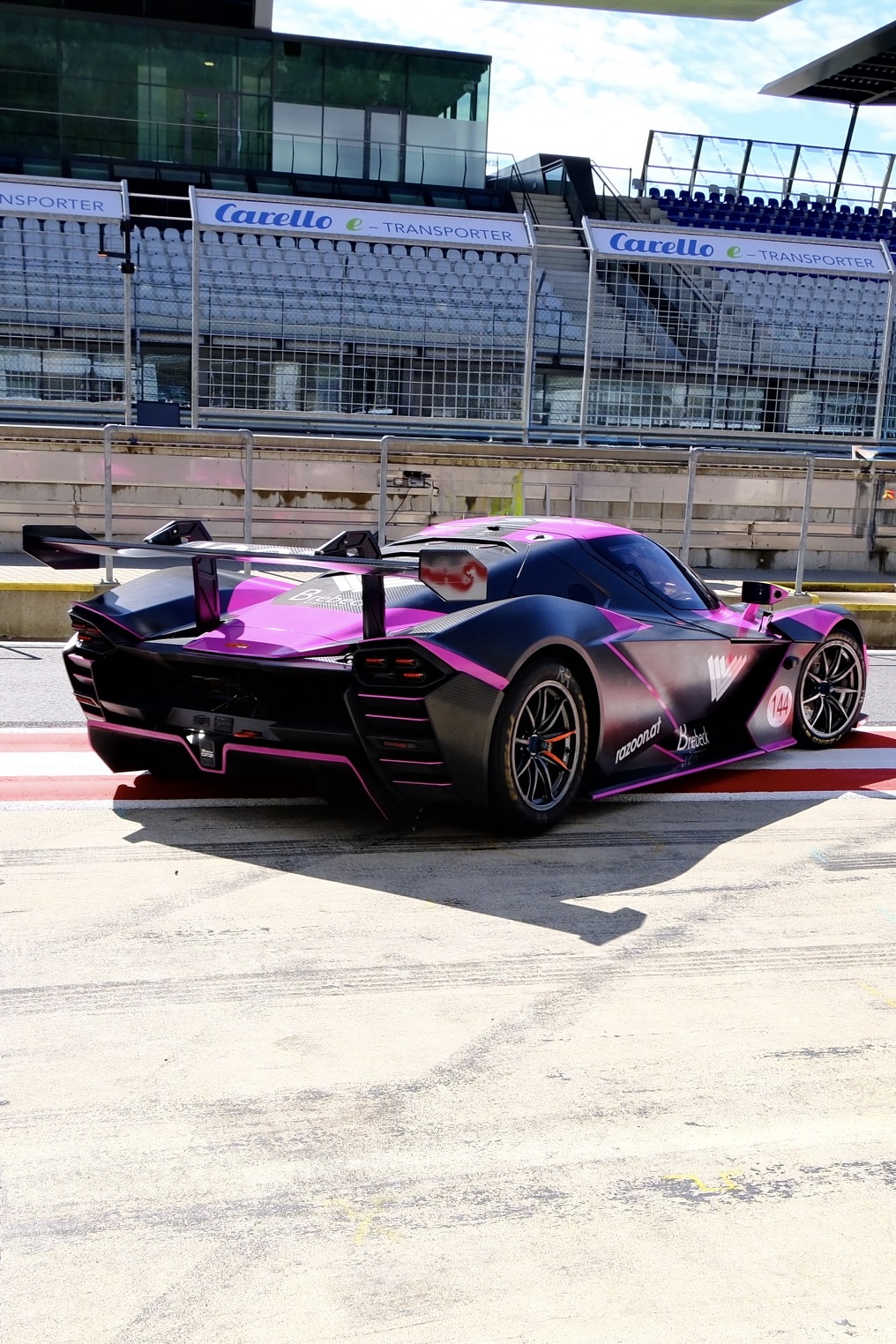 Eine XBow, d.h. ein nicht-straßenzugelassener Sportwagen fährt aus der Box auf die Boxengasse des Red Bull Rings.