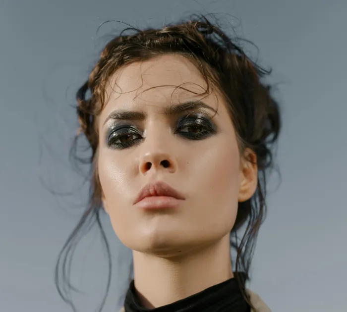 woman looking intensely at camera with dark eyeshadow and dark hair