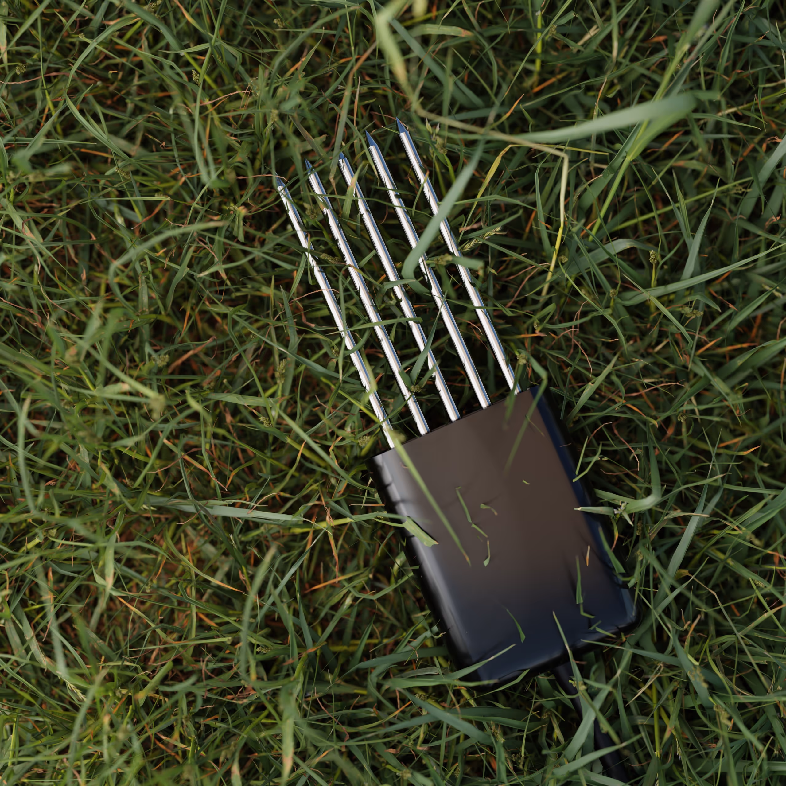 Black 5 prong soil probe resting on green grass.