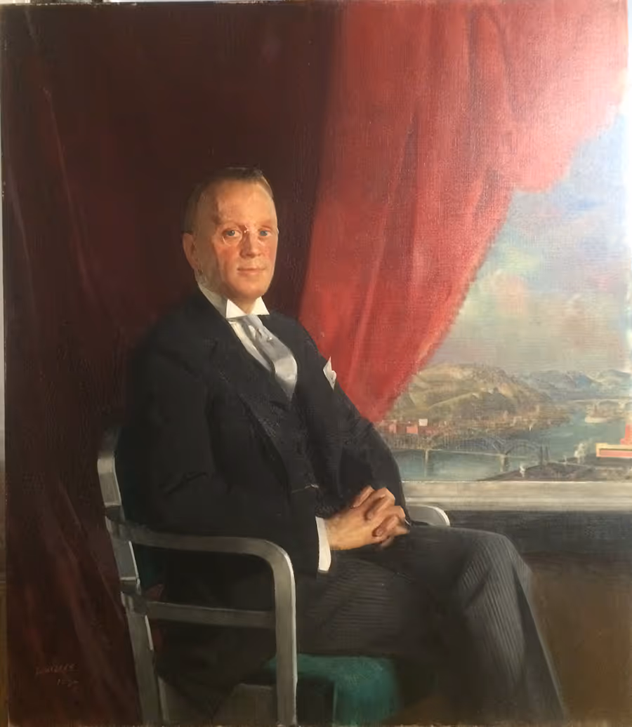 Portrait of a man in a dark suit seated on a chair with a red curtain and scenic landscape with bridges in the background.