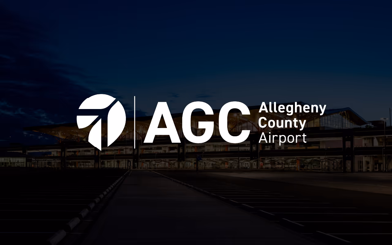 Logo for Allegheny County Airport with stylized A symbol and letters AGC over nighttime airport terminal background.