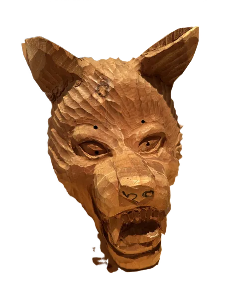 Carved wooden wolf head sculpture with open mouth and detailed facial features.