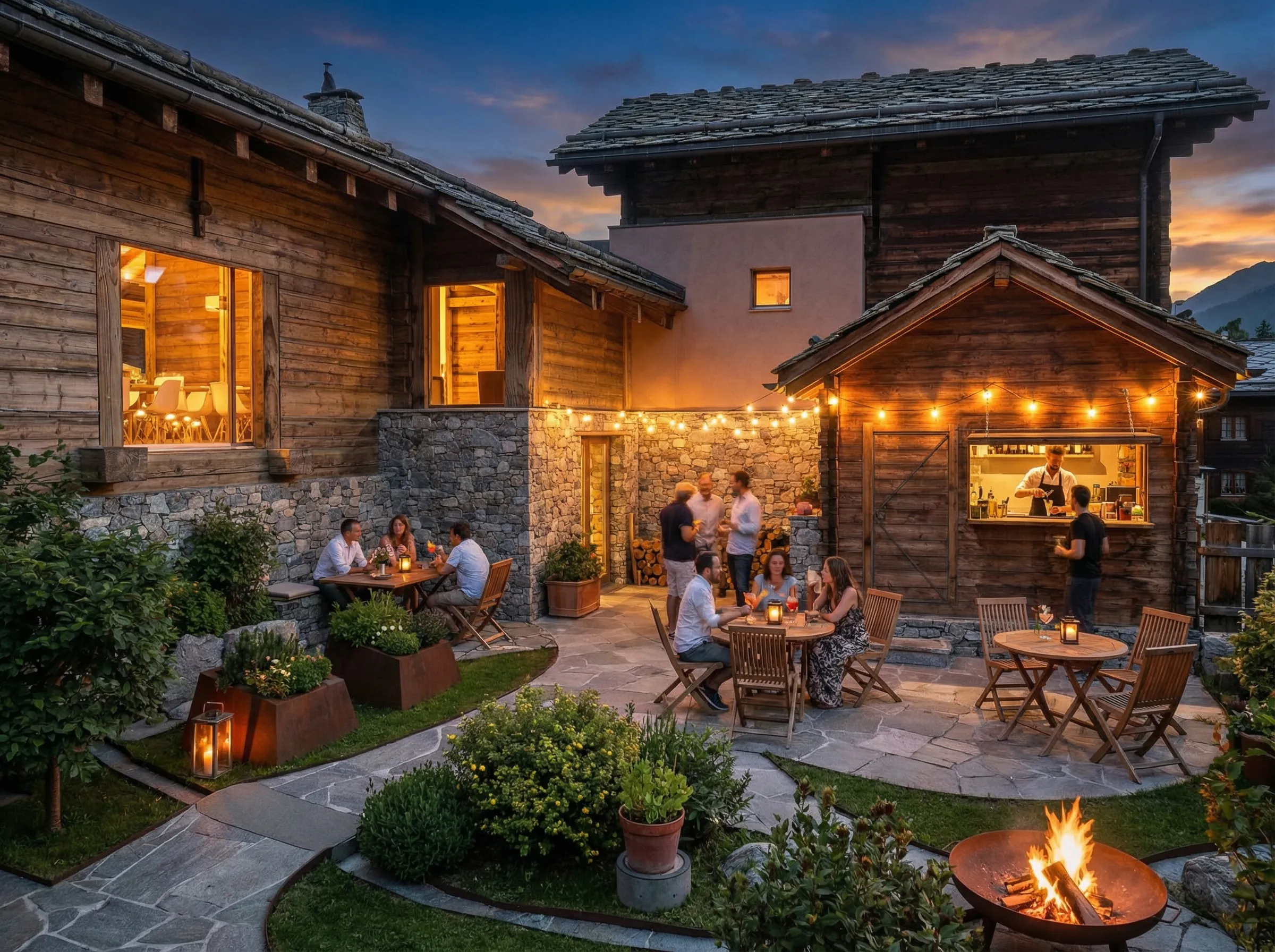 People dining and socializing outdoors at a rustic lodge patio with string lights and a fire pit at twilight.