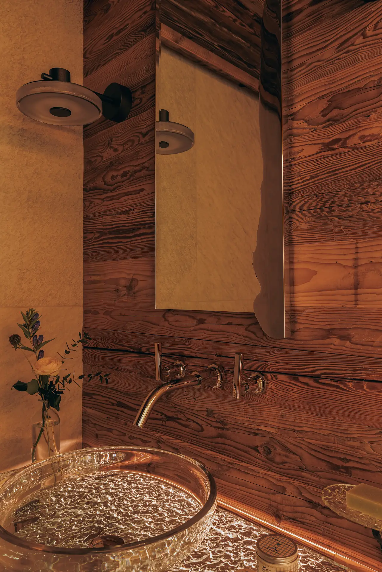Glass vessel sink on a live-edge glass counter against a wood-paneled wall