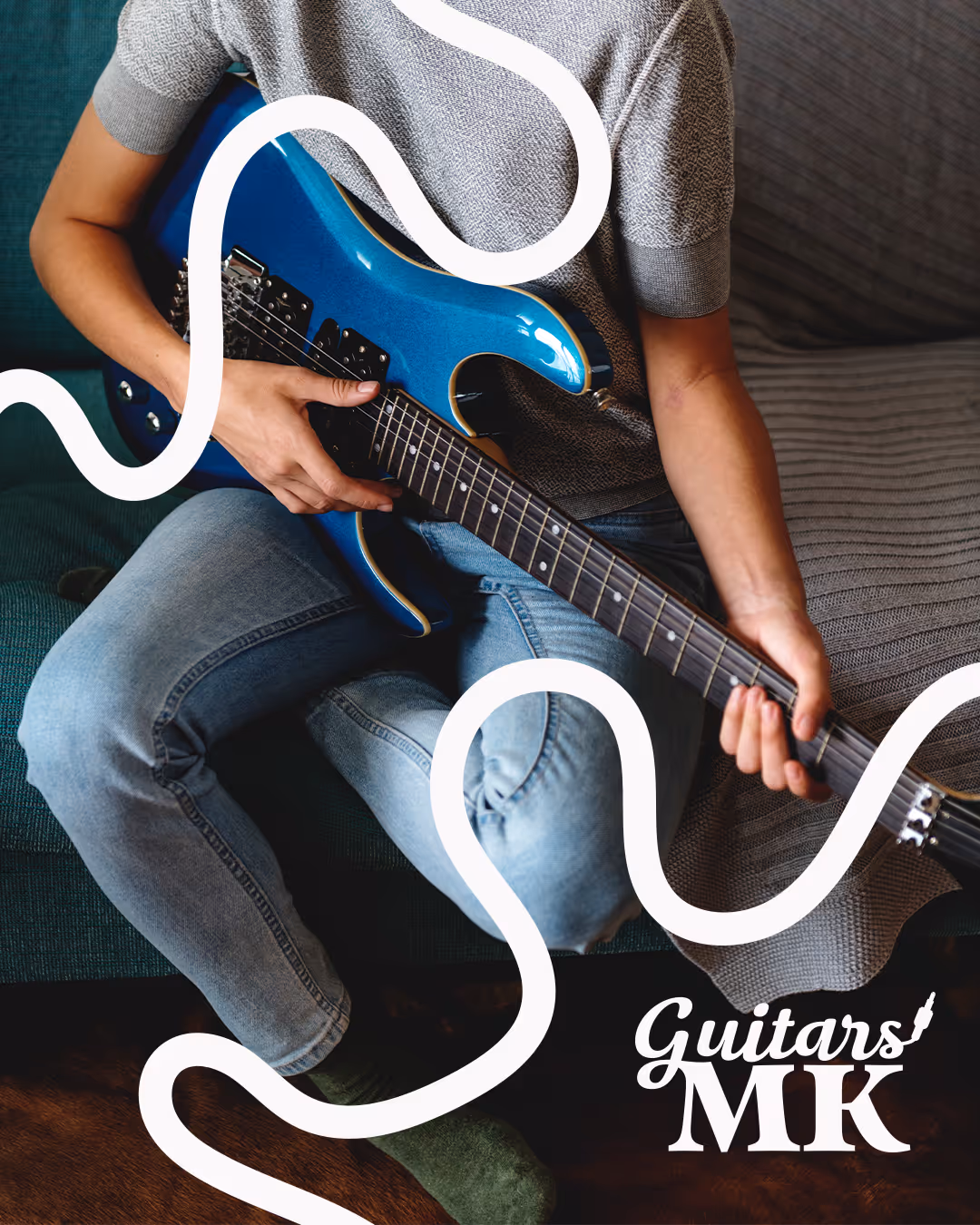 Close-up of two white electric bass guitars on a textured wood background with a dark wavy line — Guitars MK logo visible.