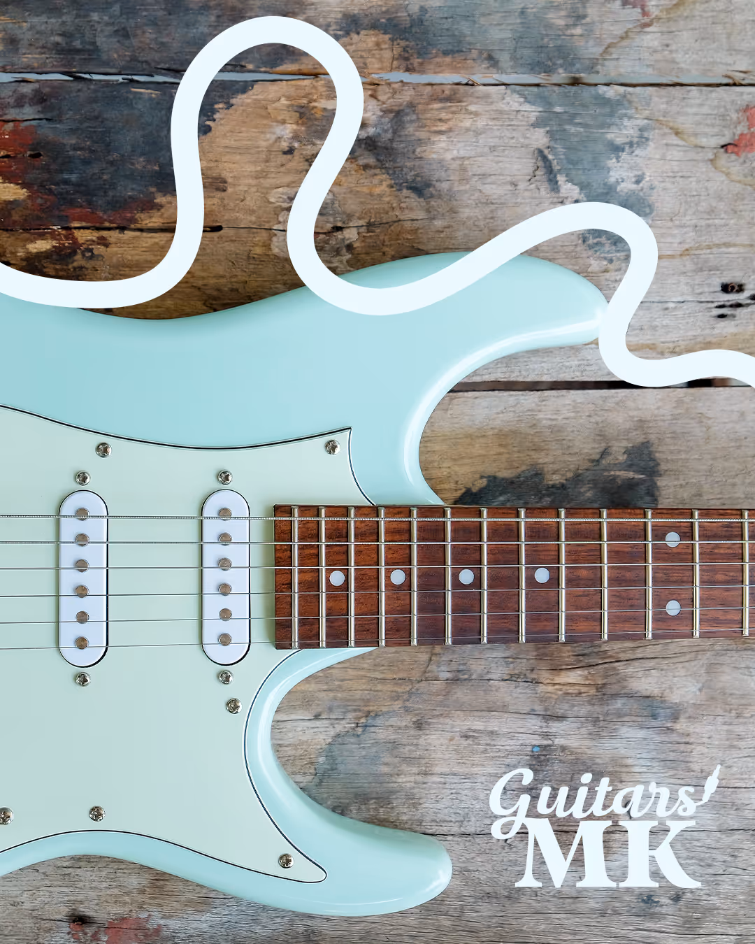 Light blue electric guitar on a rustic wooden surface with a white cable outline — Guitars MK branding in the corner.