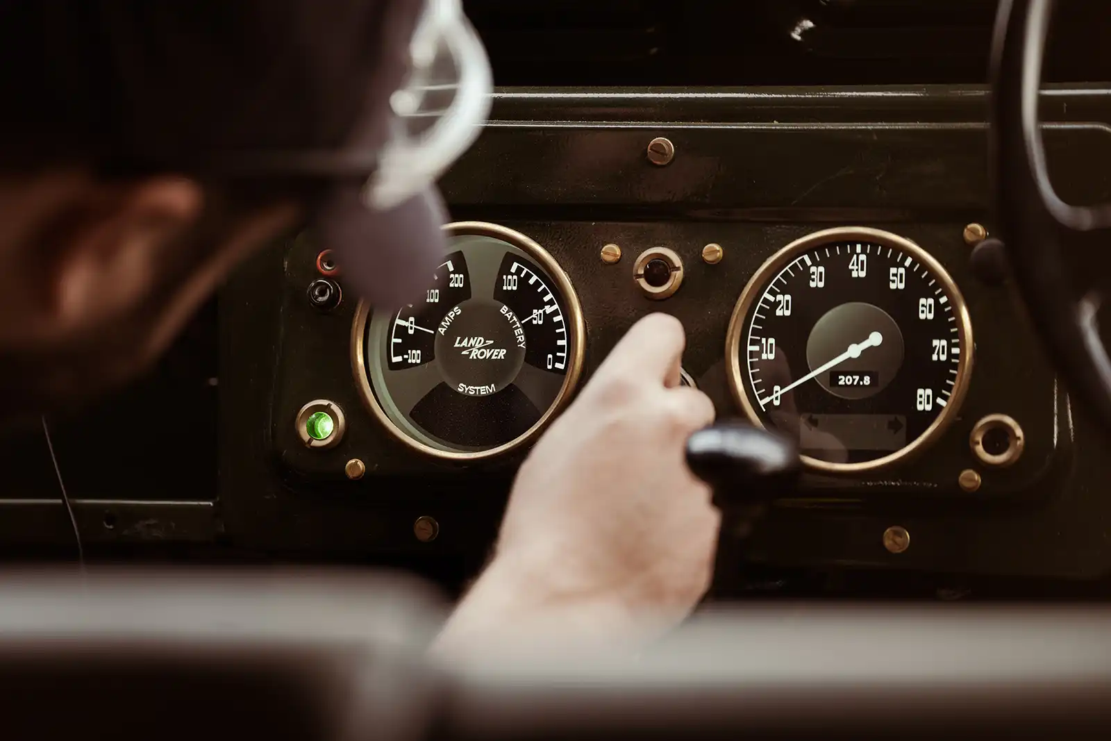 Vintage Land Rover dashboard with classic analog gauges and green indicator light