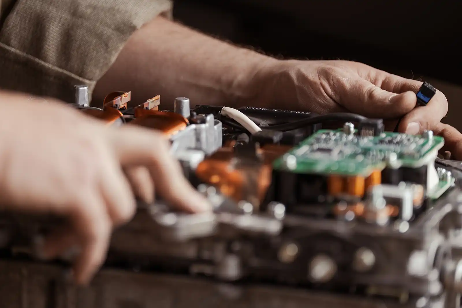 Hands repairing electronic circuit board with various metal components
