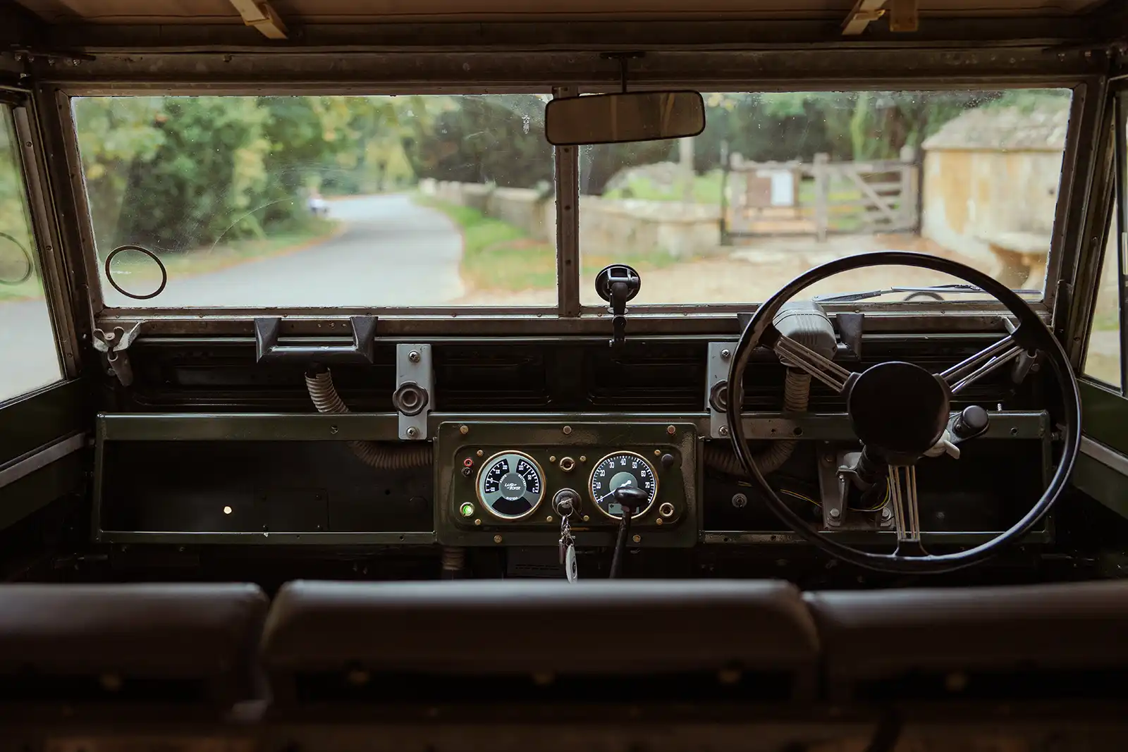 Vintage Land Rover interior view with rural countryside through windshield