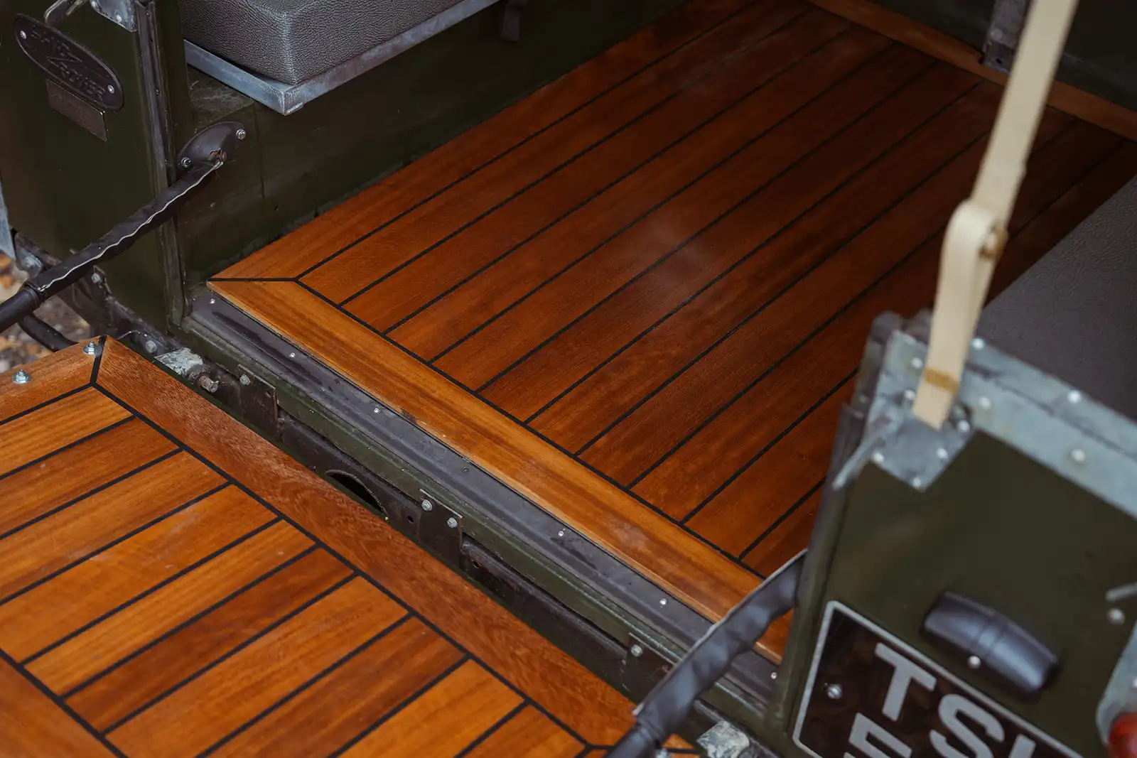Wooden deck with black lines and metal frame of vehicle or boat