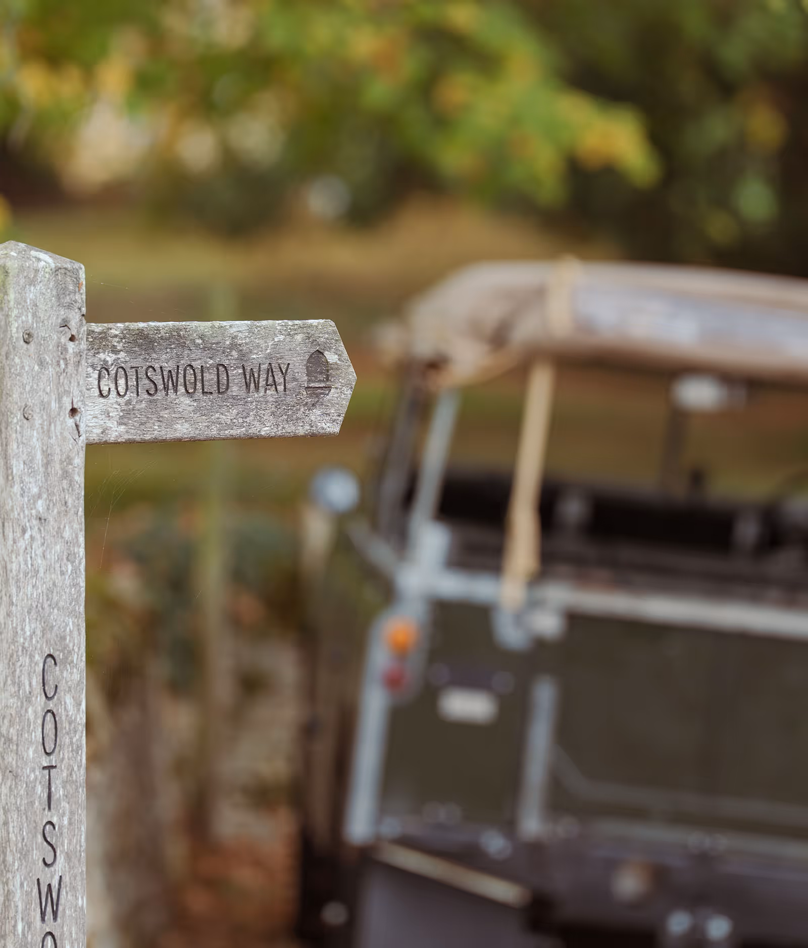 Cotswold Way signpost with vintage car in blurry background