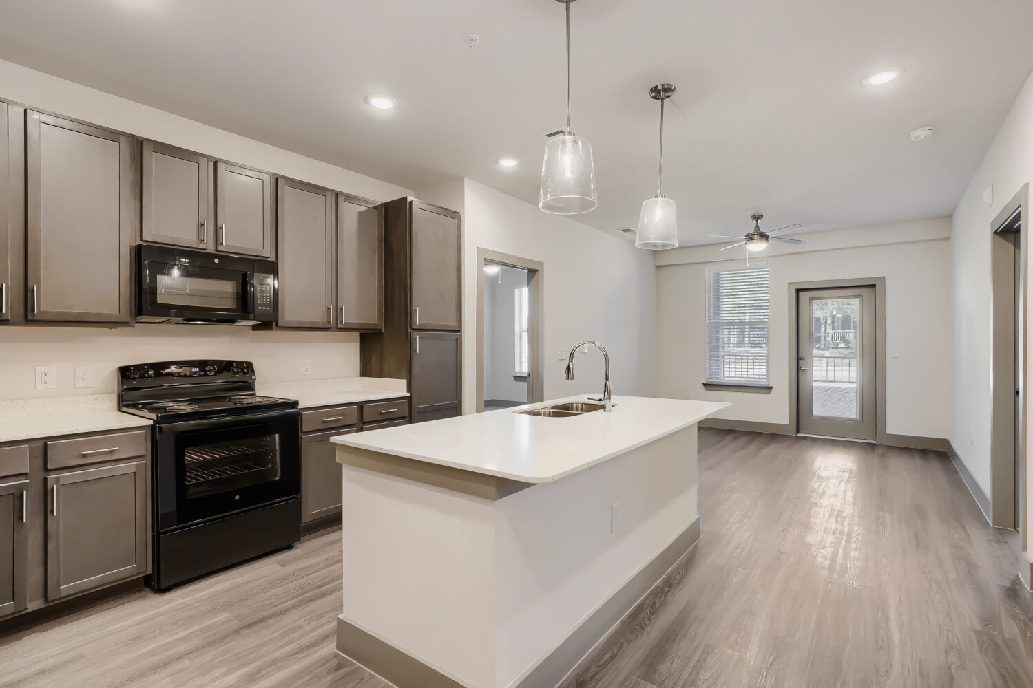 Kitchen with island, brown cabinets and black appliances