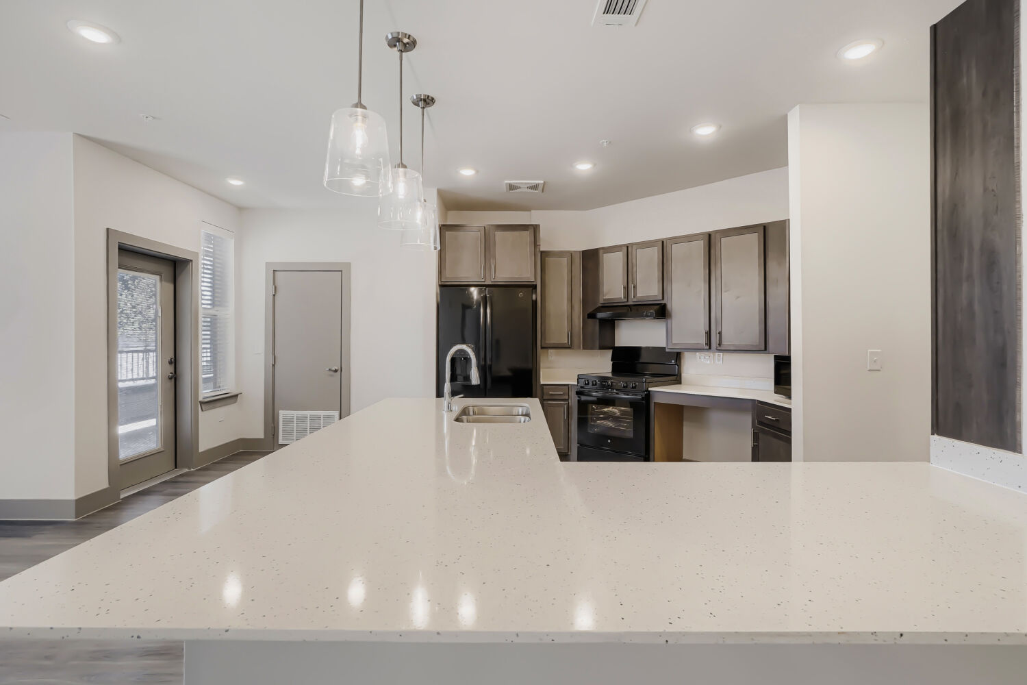 Kitchen with island, brown cabinets and black appliances
