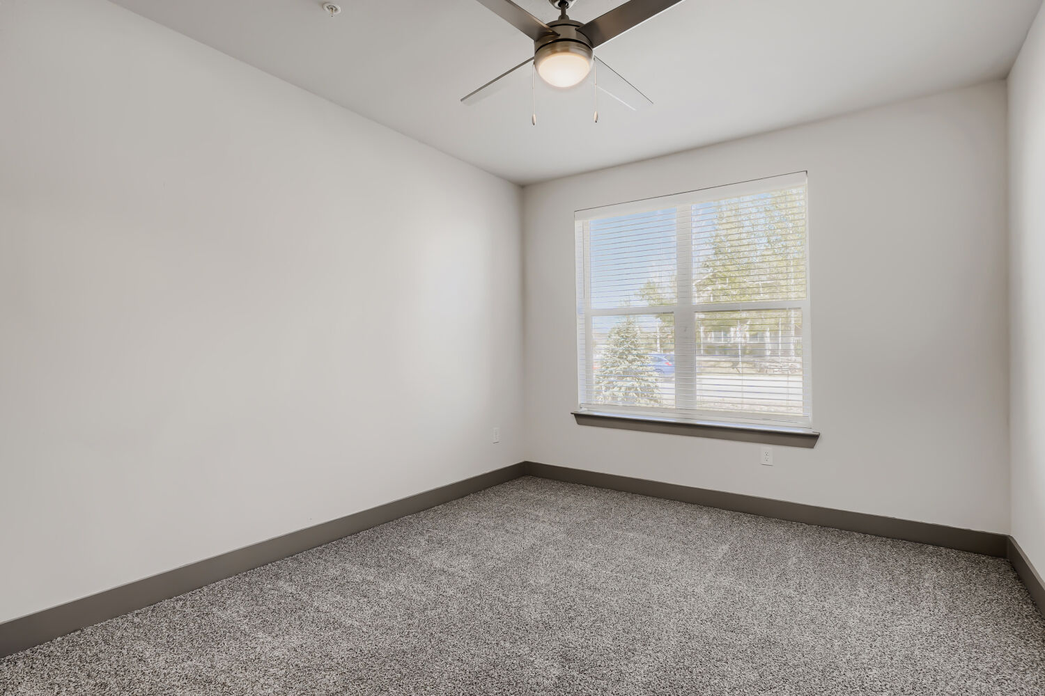 Unfurnished bedroom with large window and carpet