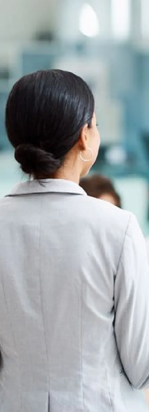 A woman in a business suit talking on a cell phone.