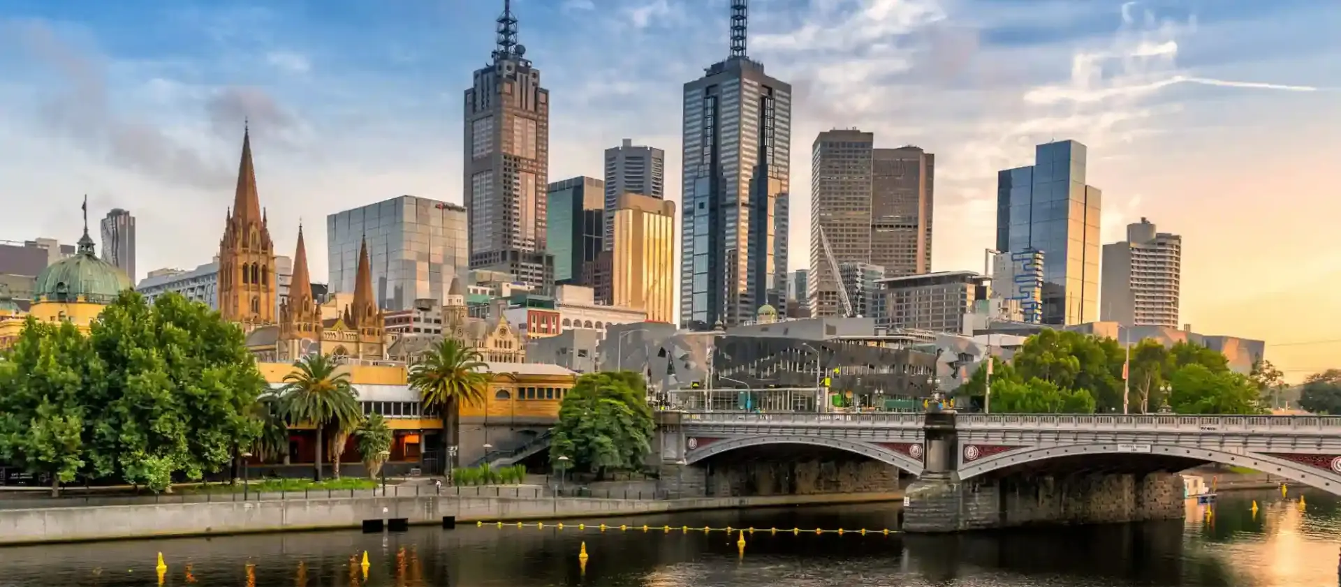 A city skyline with a bridge over a river.
